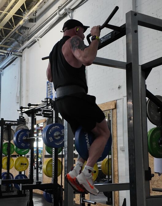 Julian performing weighted pull-ups